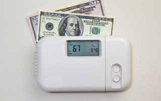 In door heating thermostat set at a room temperature and money