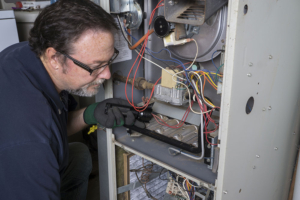 HVAC technician that is checking on a humming furnace