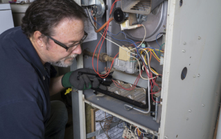 HVAC technician that is checking on a humming furnace